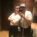 Peri taking a mirror selfie with her host dad wearing white shirts and hats